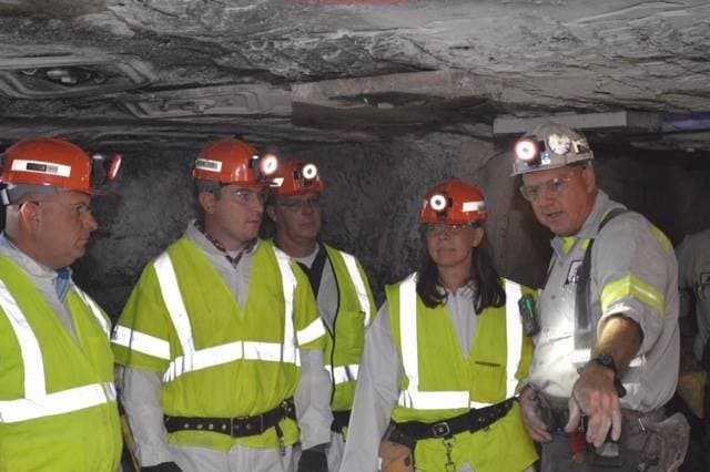 Underground coal mine tour with guide gesturing